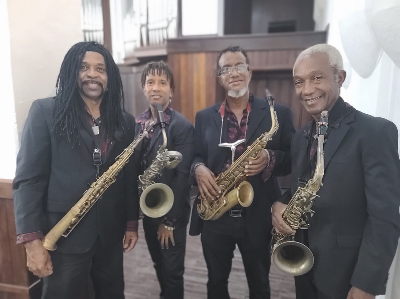 Los cuatro integrantes de Magic Sax Quartet con trajes negros y sus saxofones